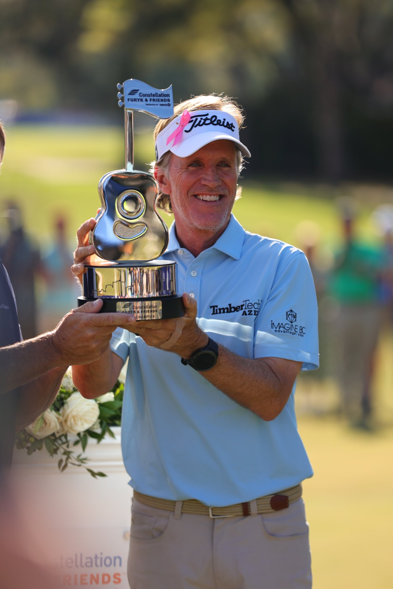 Brett Quigley raises Constellation Furyk & Friends trophy made by Malcolm DeMille